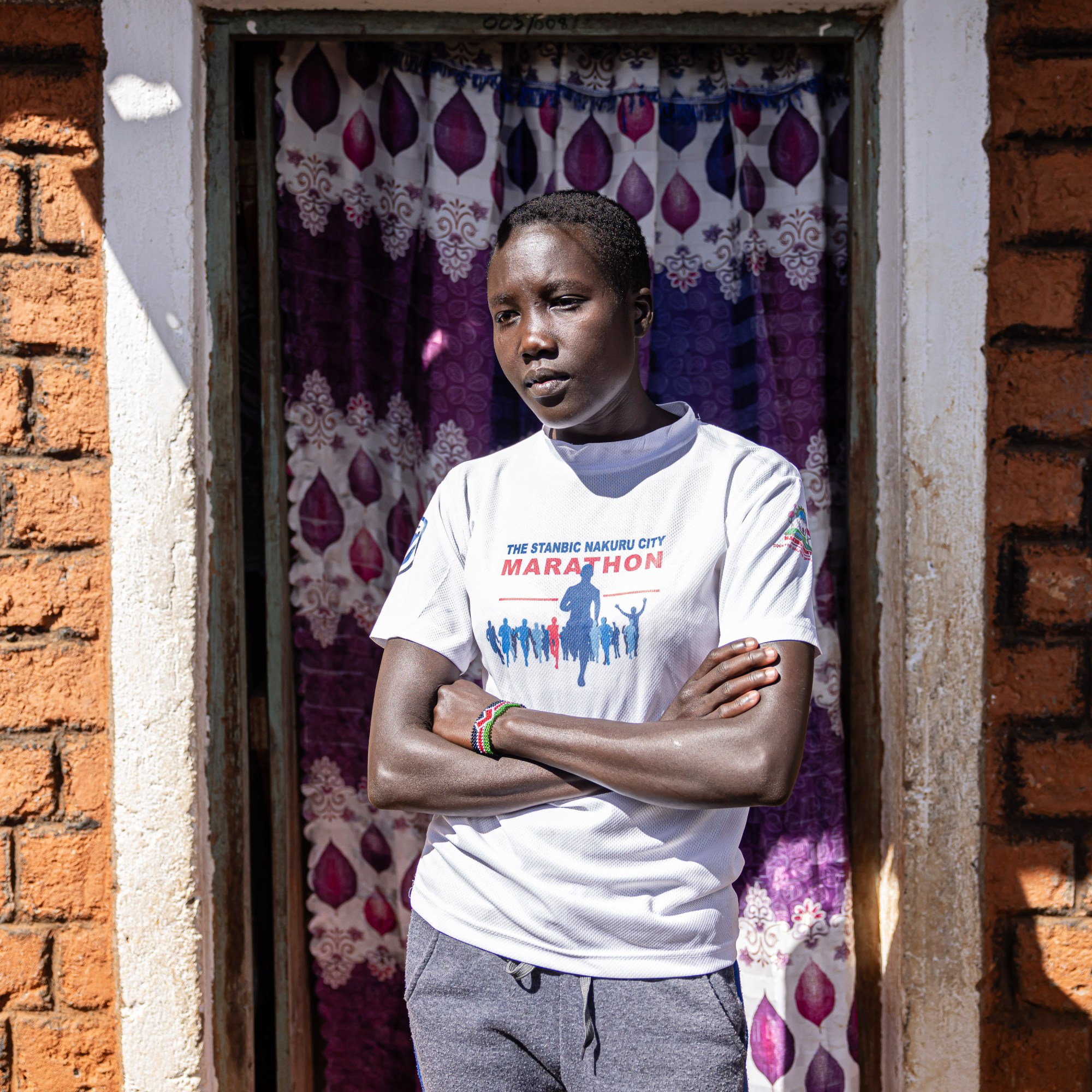 Daisie standing in a doorway with crossed arms