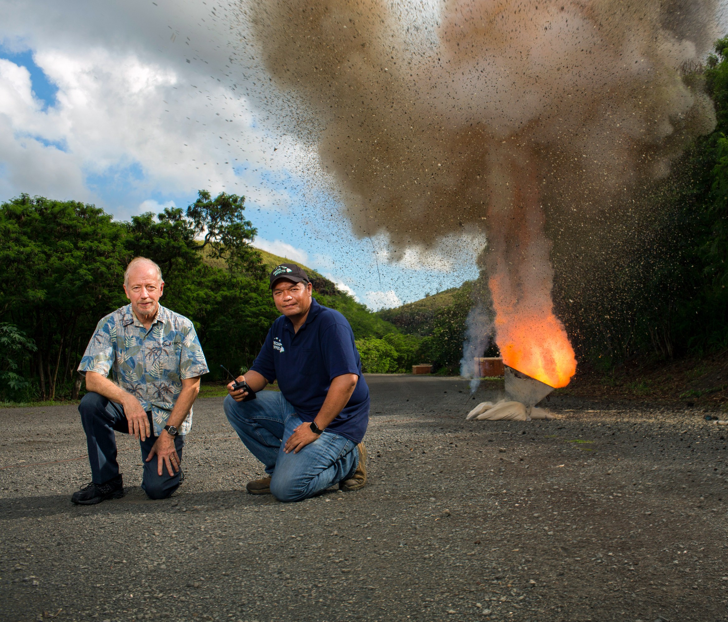 Charlie Holdaway and McLane Ahuna kneeling several yards from a fireball