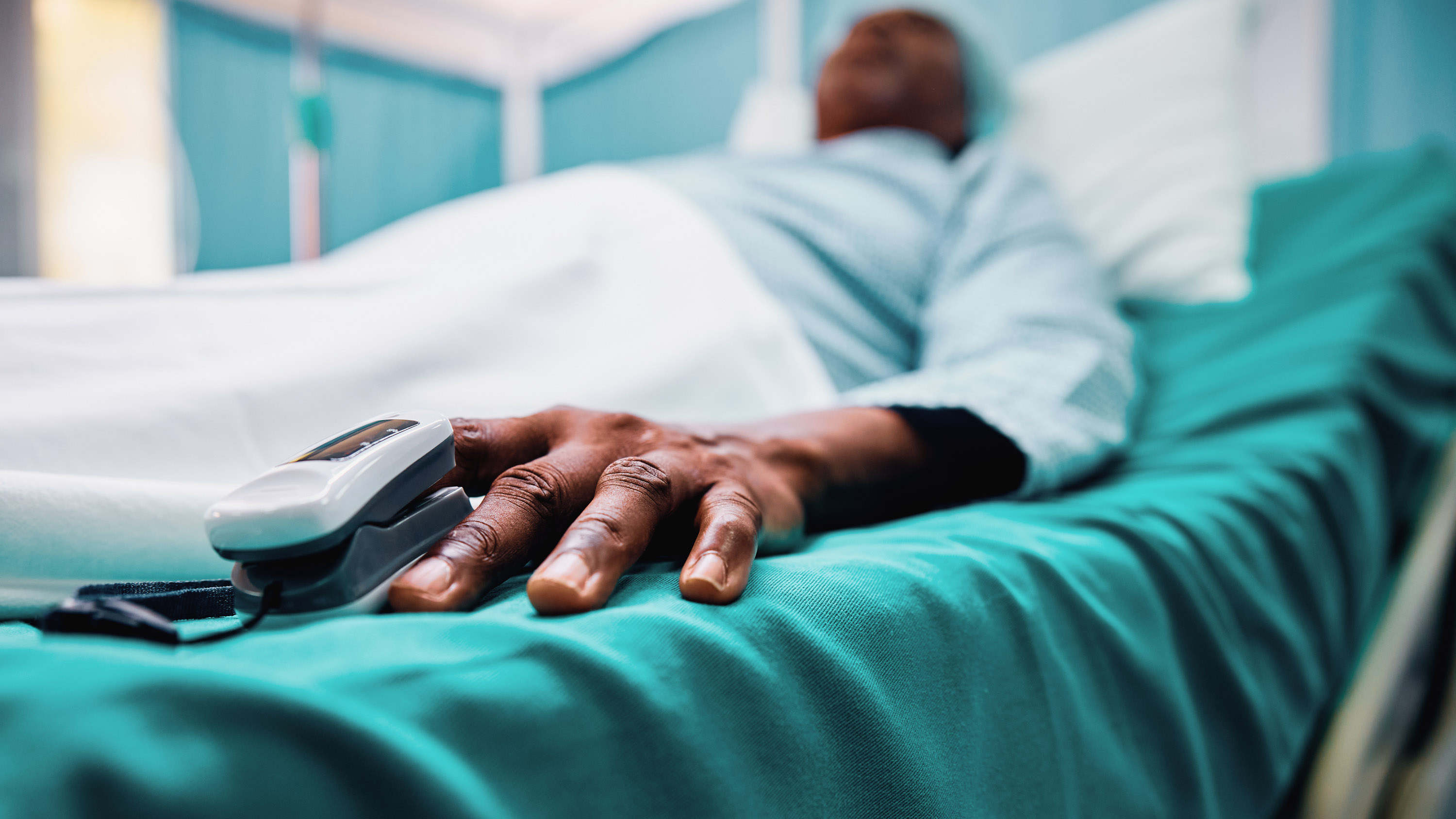 Close up of Black patient with pulse oximeter on finger in the hospital.