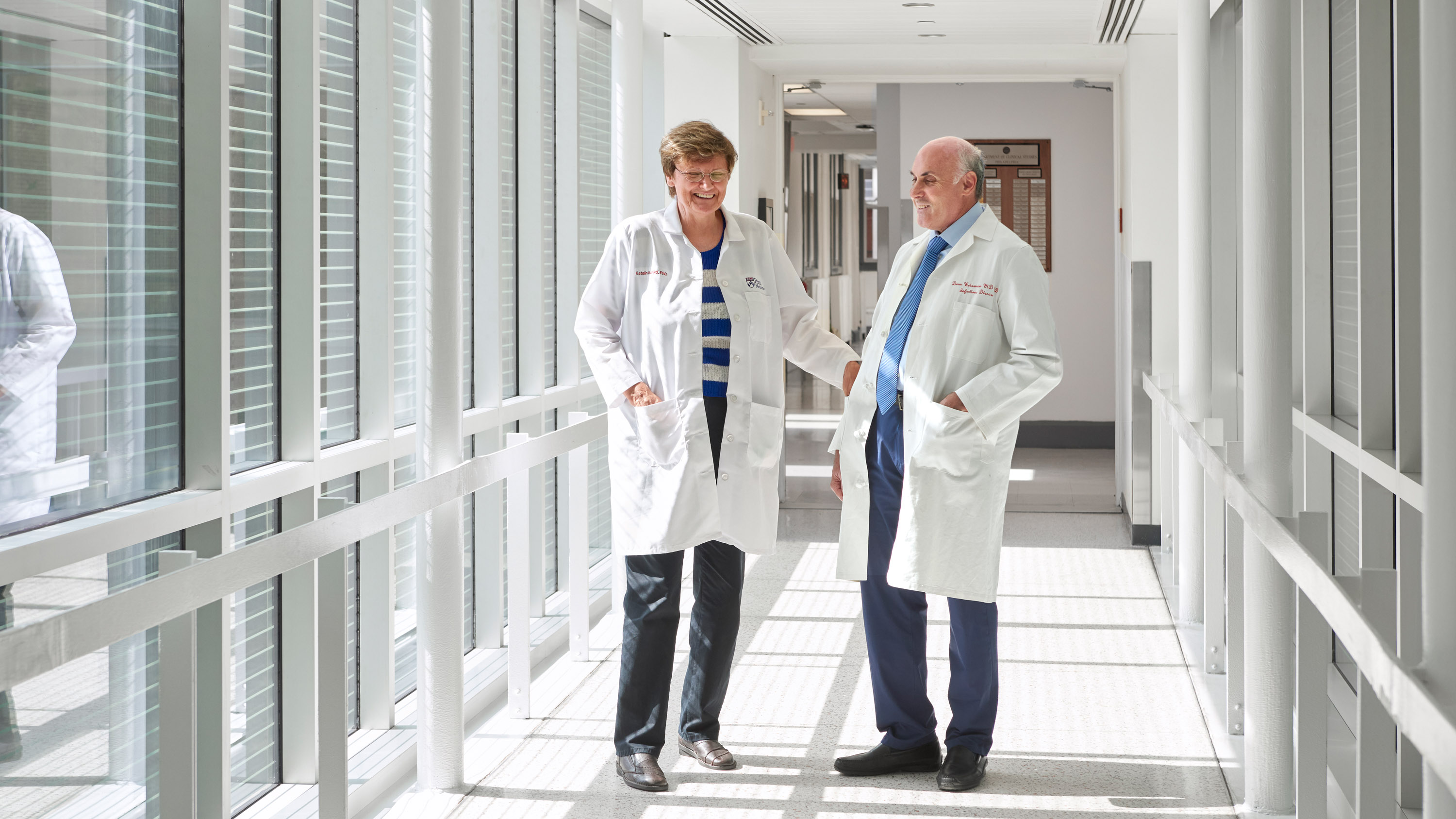 Kariko and Weissman laugh as they walk through a skybridge